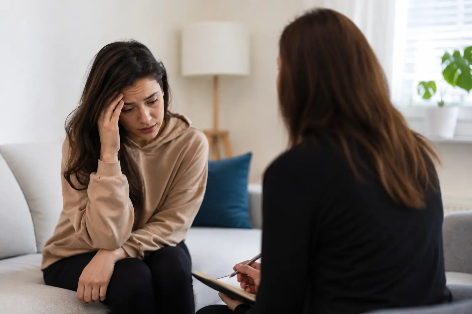 Woman speaking with a mental health professional during a therapy session about anxiety or depression treatment and medication options.